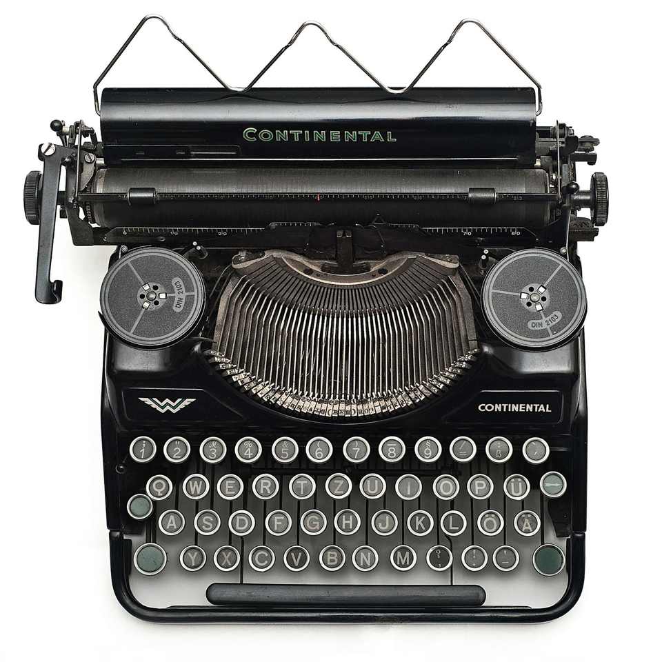 Vintage typewriter on a clean white surface, signalling deliberate authorship of a brand narrative