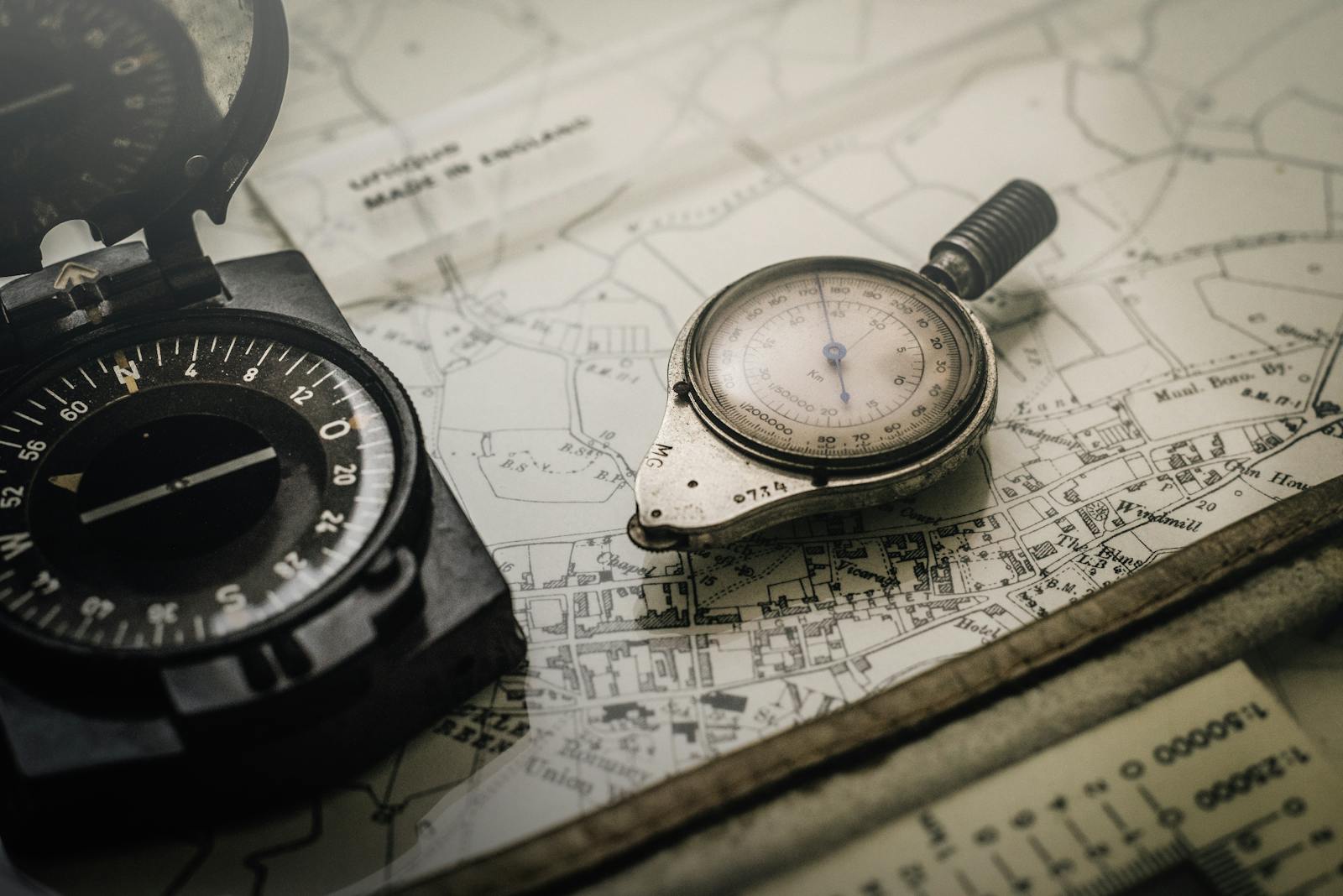 Antique brass compass and dividers resting on a navigational chart