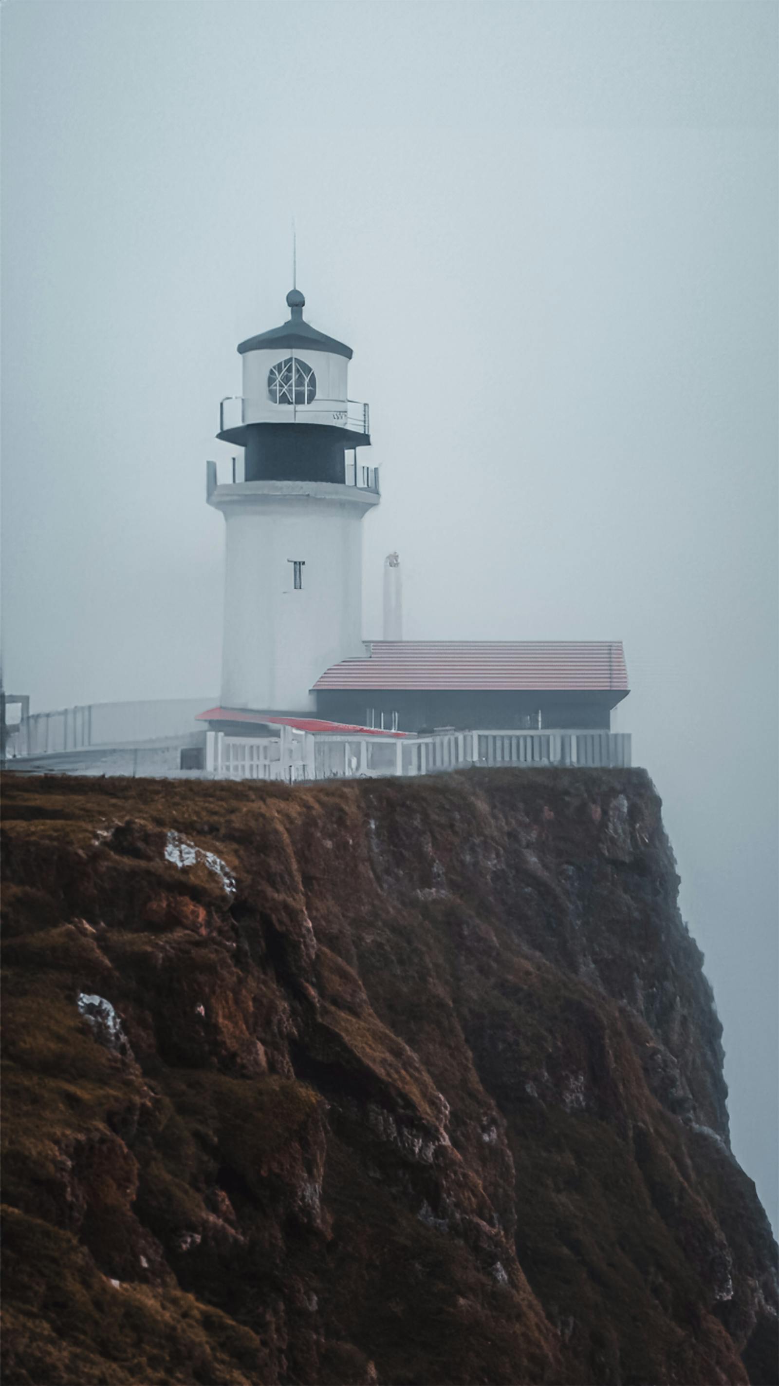 Lighthouse beam reaching through evening sea fog
