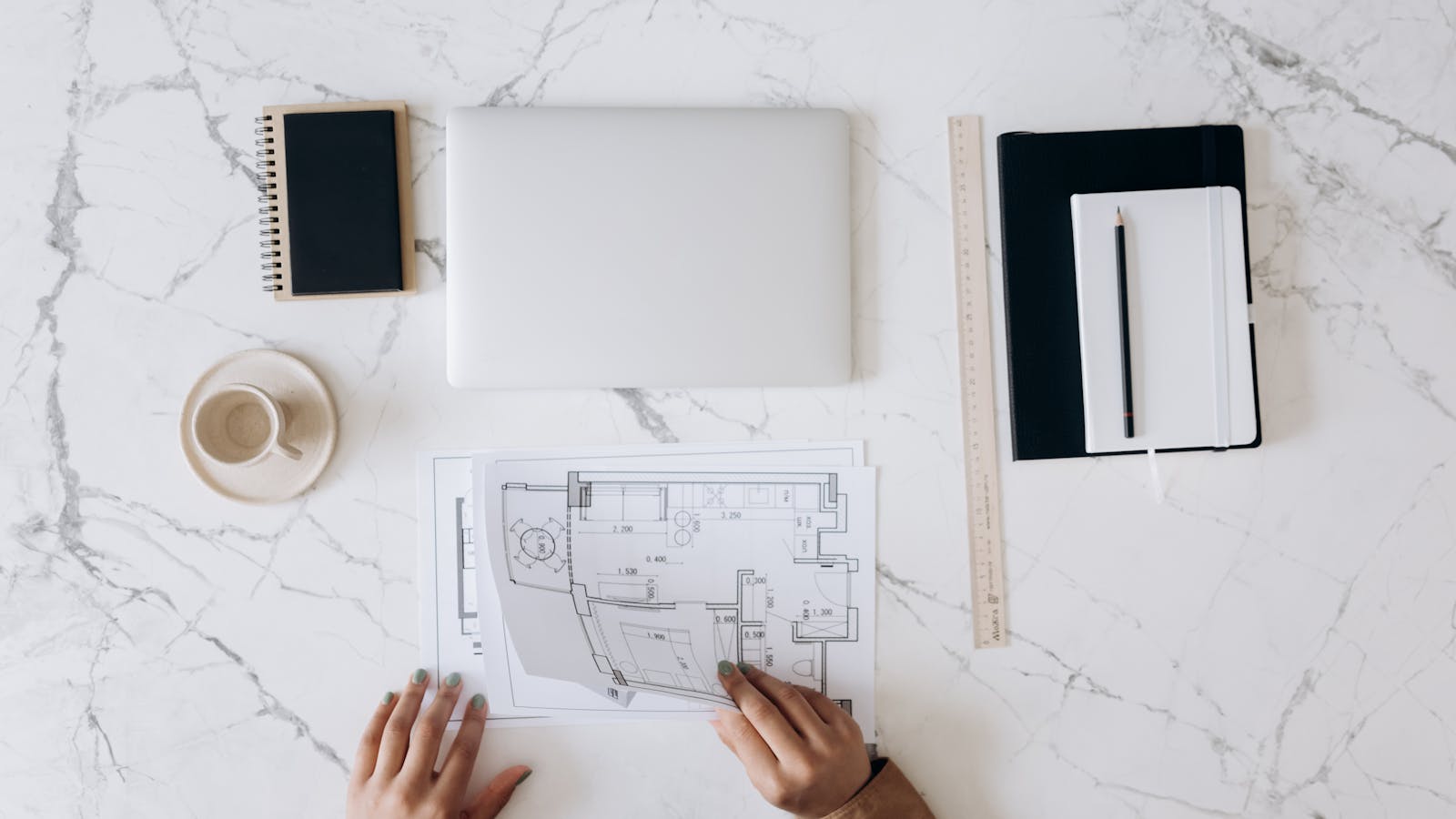 Detailed architectural blueprint and measurement tools laid out on a clean workspace