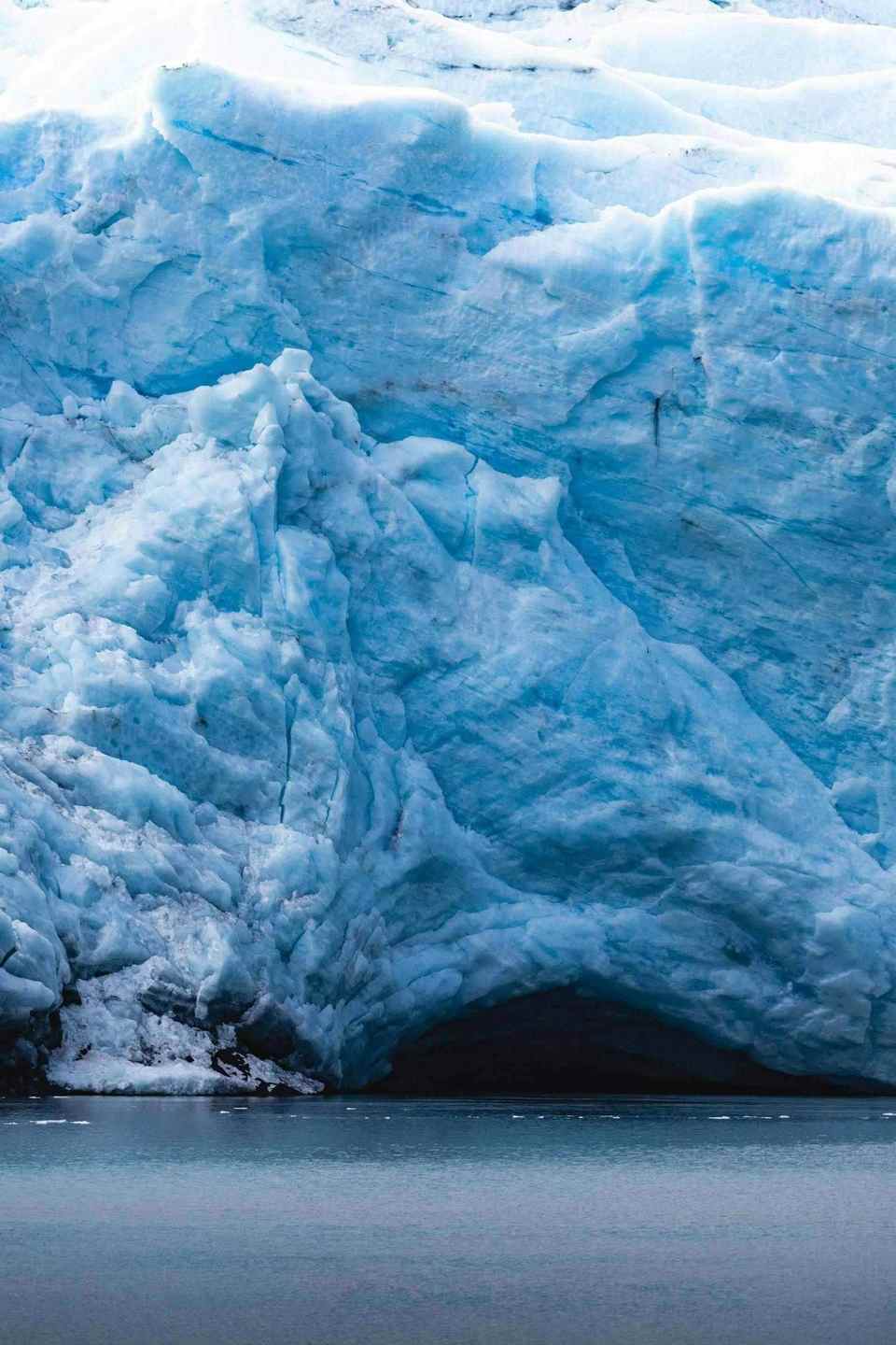 Single iceberg on a calm ocean, only a fraction visible above the waterline