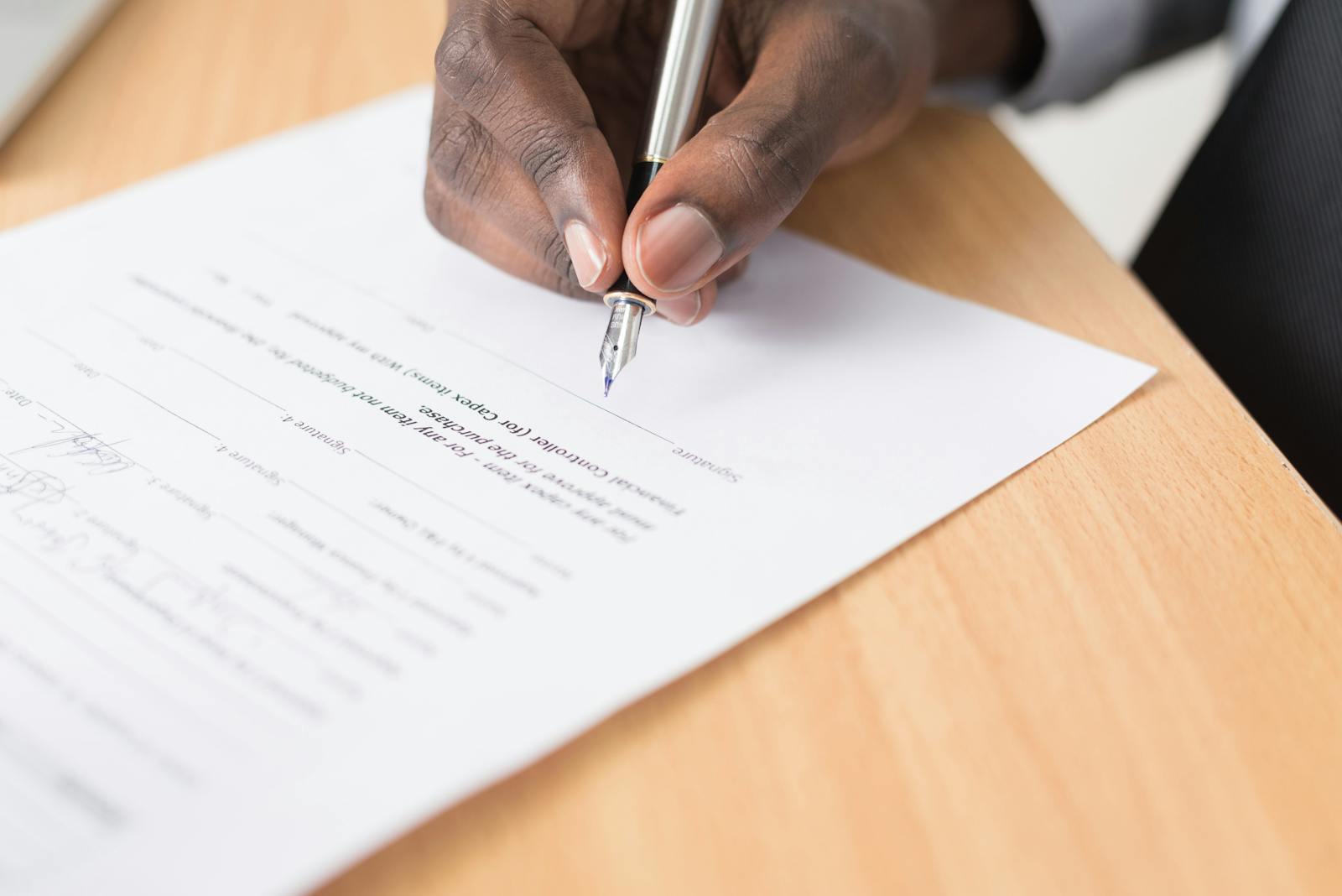 Hand signing a commercial agreement representing enterprise lead conversion and deal commitment