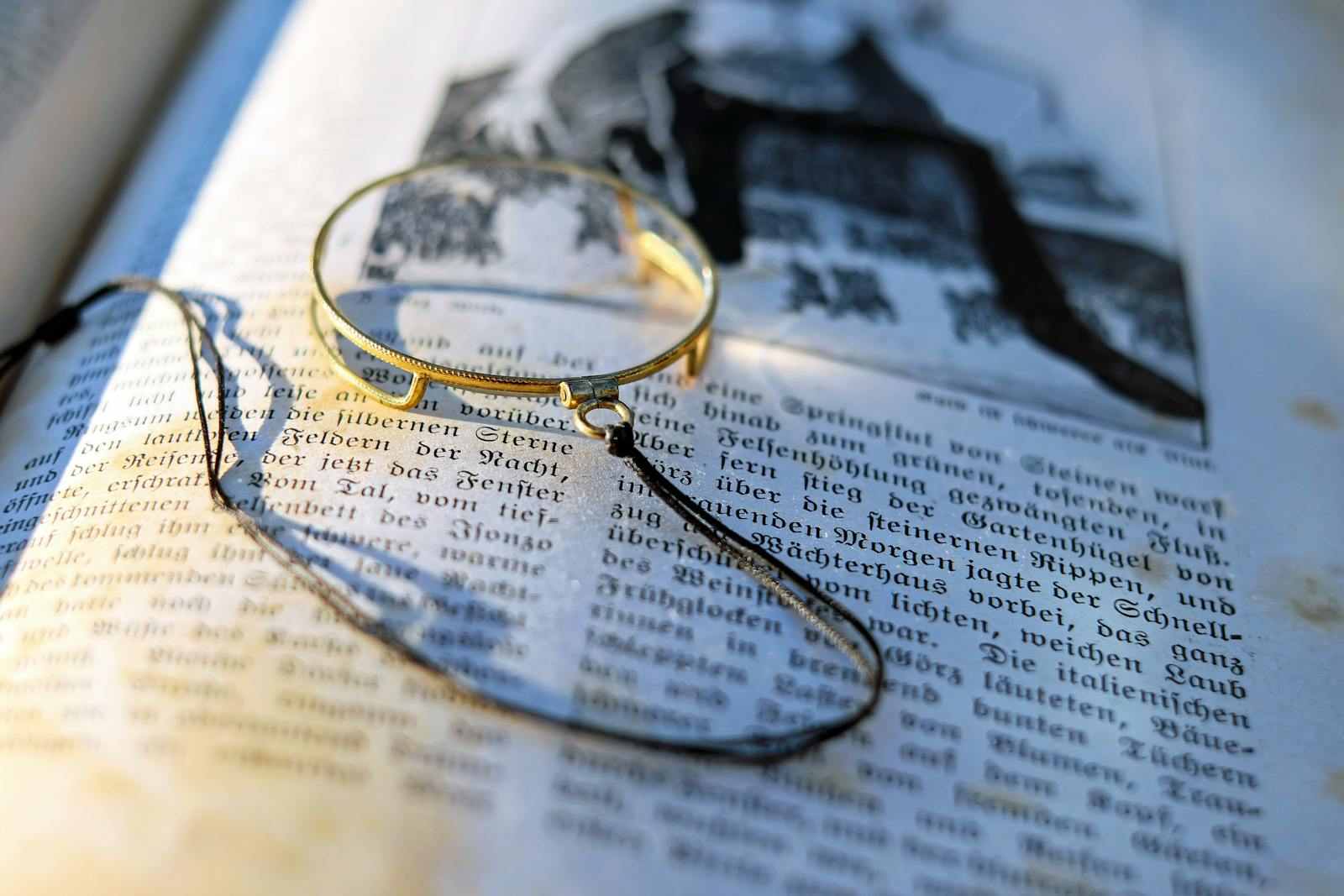Vintage magnifying glass resting on the page of an opened book